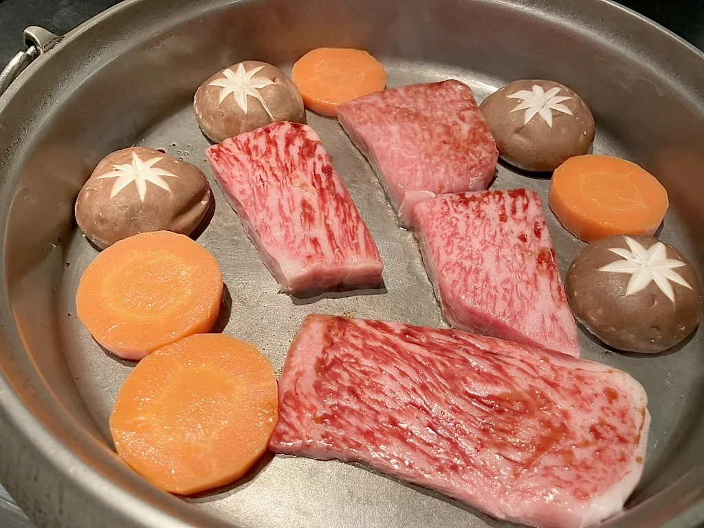 ออยล์ยากิของ Moritaya ที่มีเนื้อวัว เห็ดหอม และแครอทวางในกระทะ