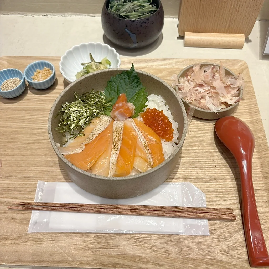Nasi dengan topping salmon dan lauk pendamping kecil